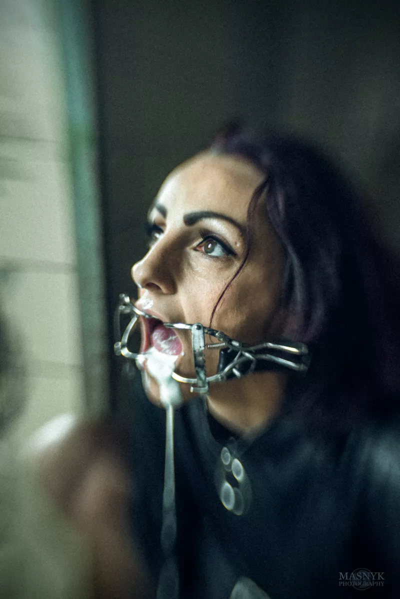 Gagged woman in straitjacket in abandoned psychiatric hospital