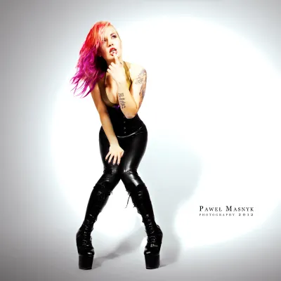 Zakneblowana kobieta w latexowym stroju w roli pony girl