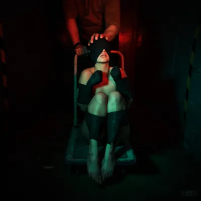 Dark urban exploration and bondage scene with a blindfolded person