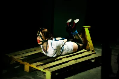 Frau mit Ballgag gefesselt in Hogtied
