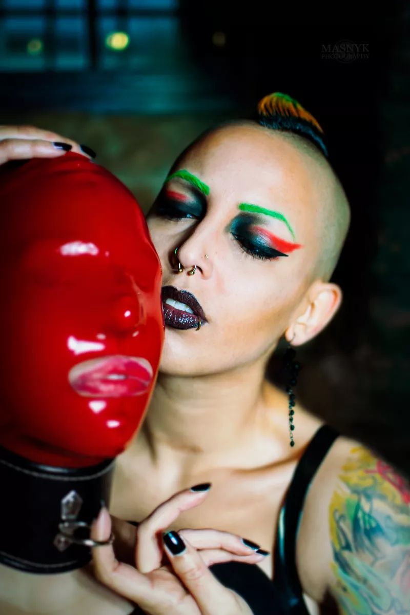 colorful dominatrix and slave girl in latex mask