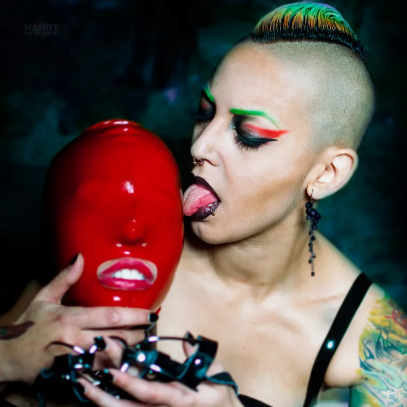colorful dominatrix and slave girl in latex mask