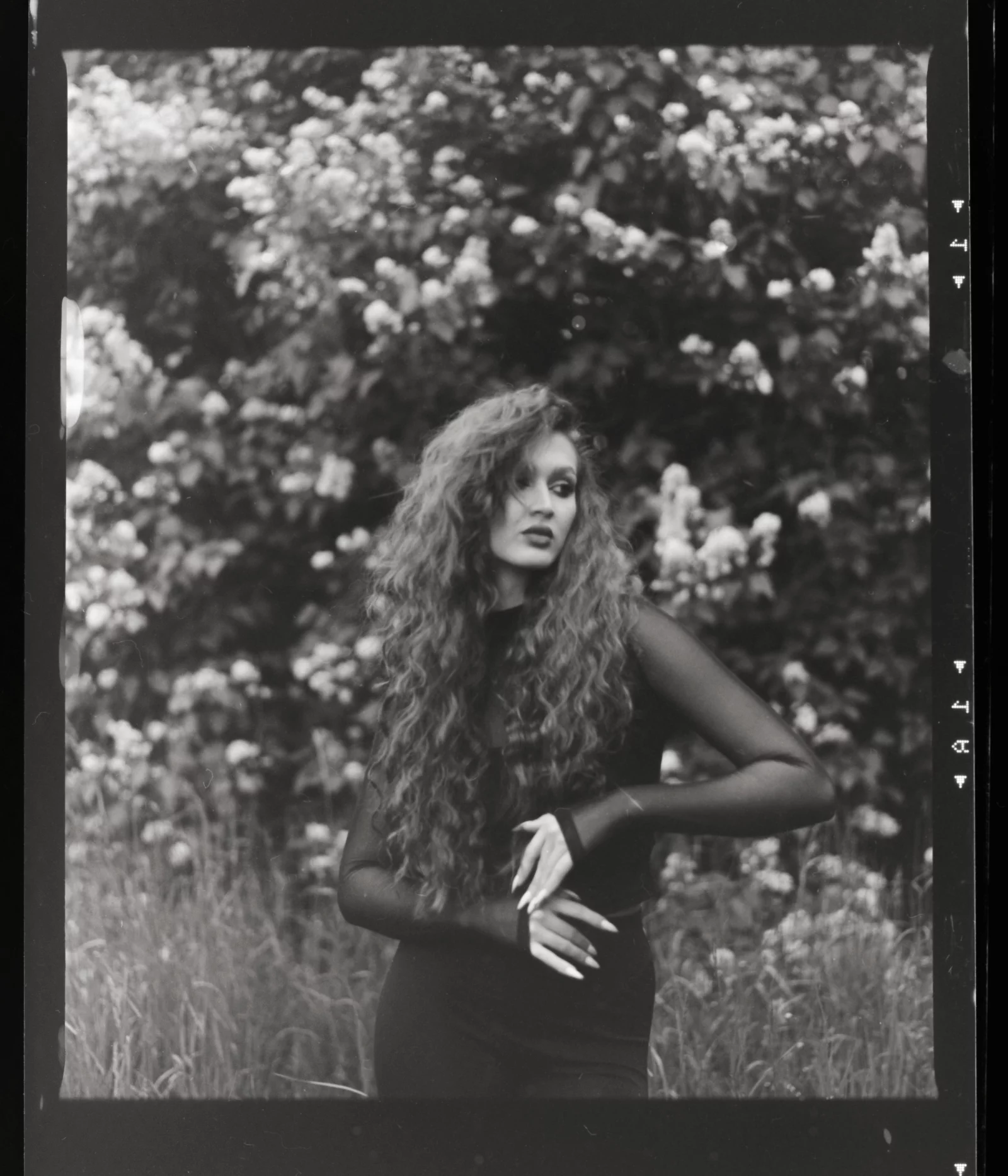 Frau mit langen lockigen roten Haaren und schwarzem Netzoberteil