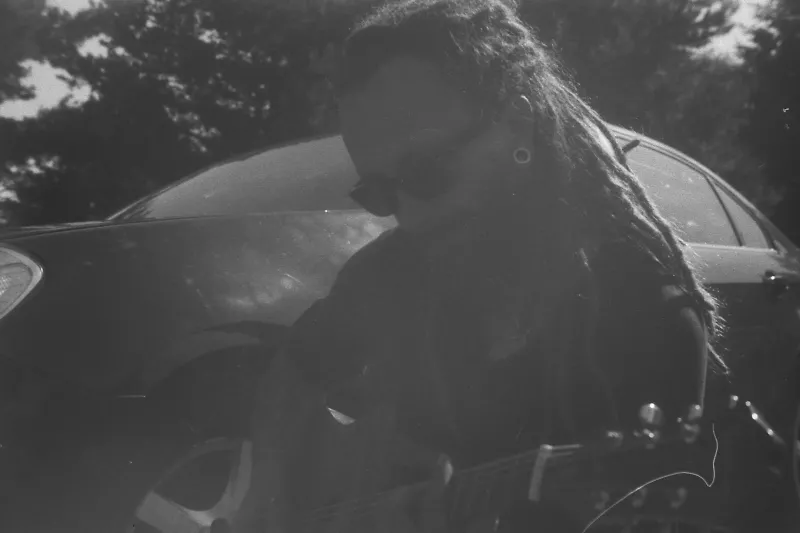 Mężczyzna w dredach gra na gitarze - fotografia analogowa