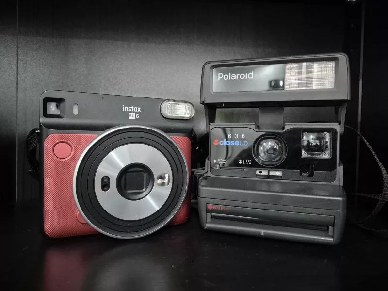 Foto einer Instax- und Polaroid-Kamera nebeneinander