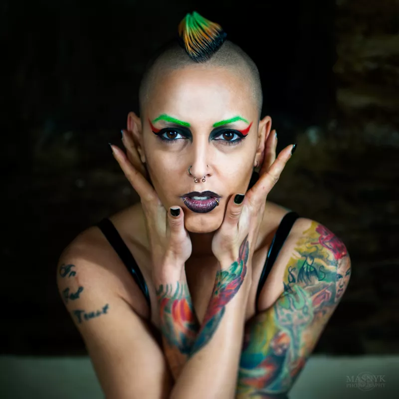 wytatułowana kobieta z piercingiem i kolorwymi włosami