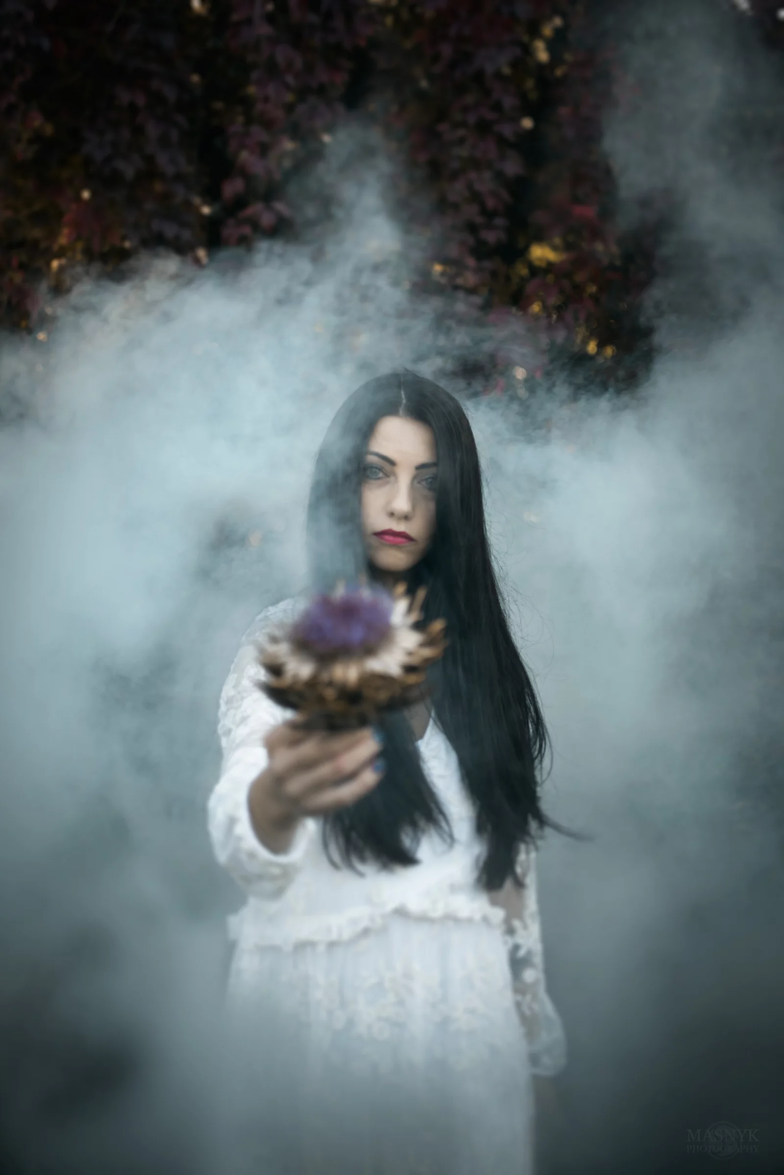 Frau mit langen Haaren und weißem Kleid steht im Nebel