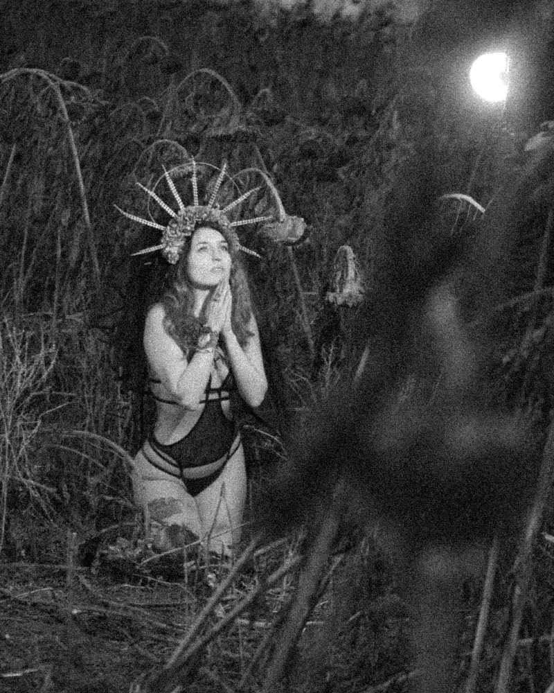 Portret kobiety w symbolicznej scenerii, ukazujący społeczne naciski na kobiecą seksualność.