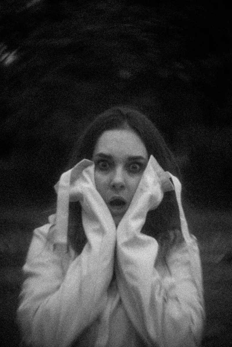 Woman in a straightjacket expressing fear in a surreal setting