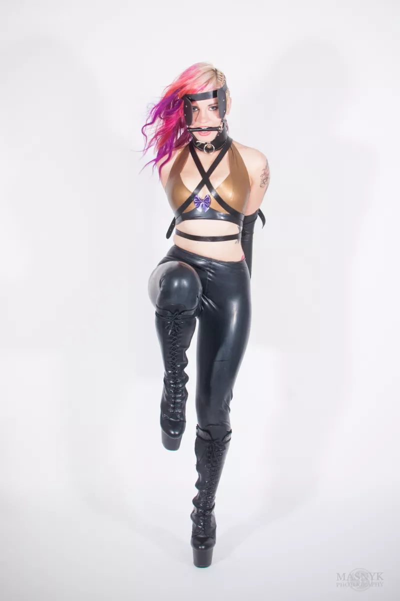 Zakneblowana kobieta w latexowym stroju w roli pony girl