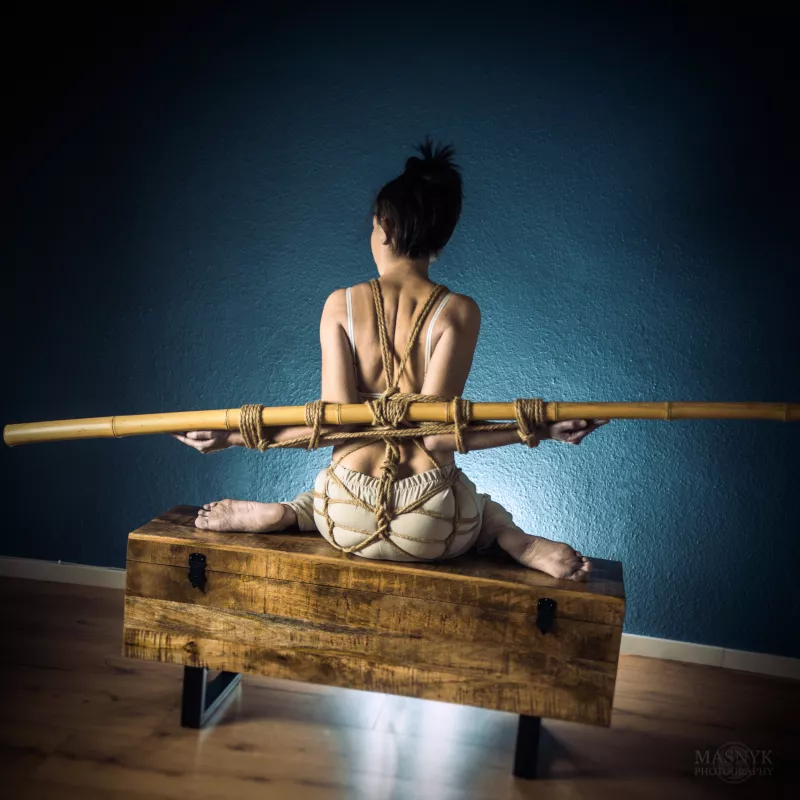 tied up girl with the use of ropes and bamboo