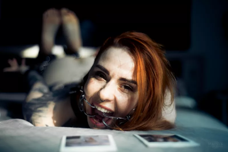 Geknebelte und gefesselte Frau auf dem Bett