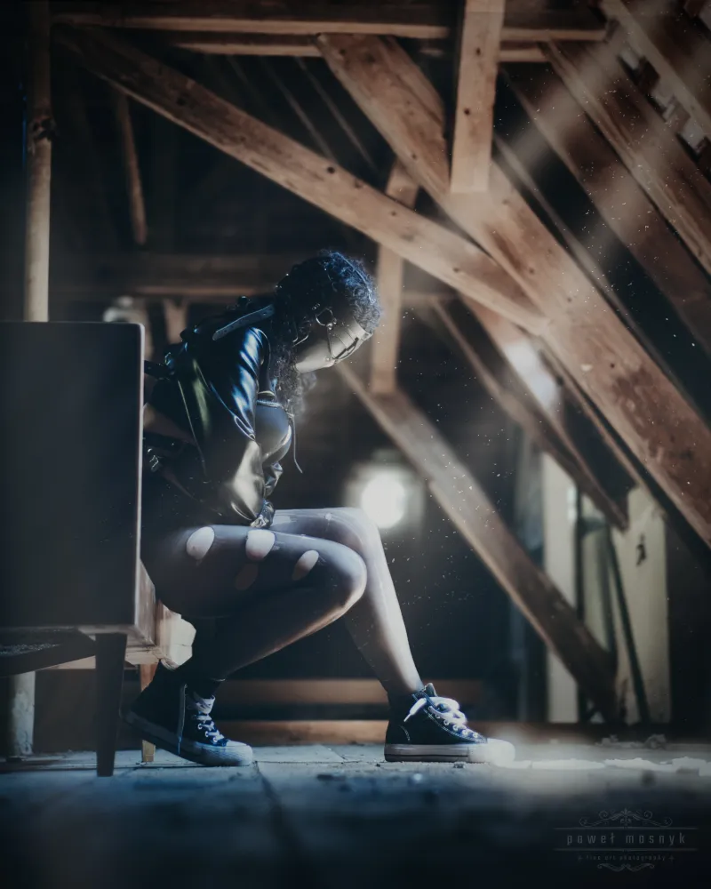 Person in a dark attic with light beams