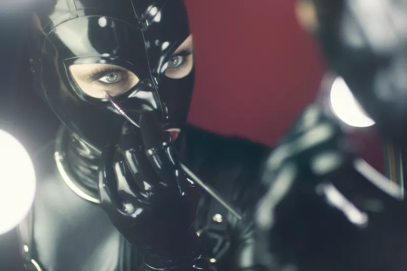Woman wearing a collar and latex mask