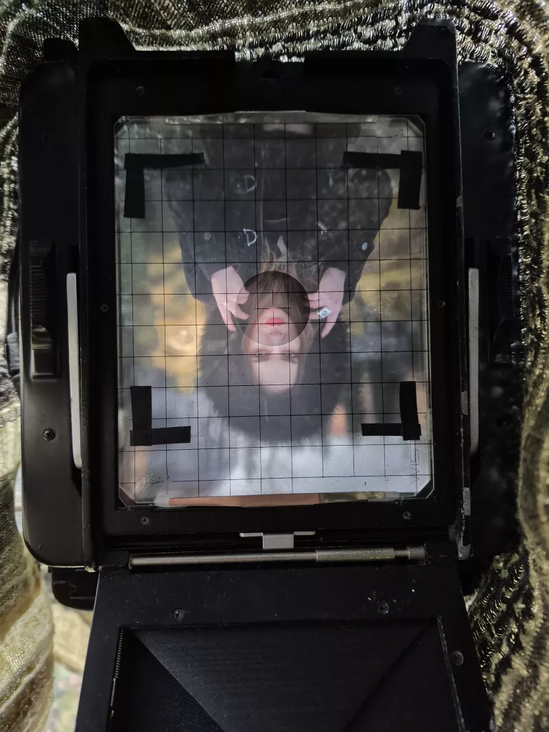 Fotograf beim Zuschneiden eines Fotos während der analogen Entwicklung in der Dunkelkammer