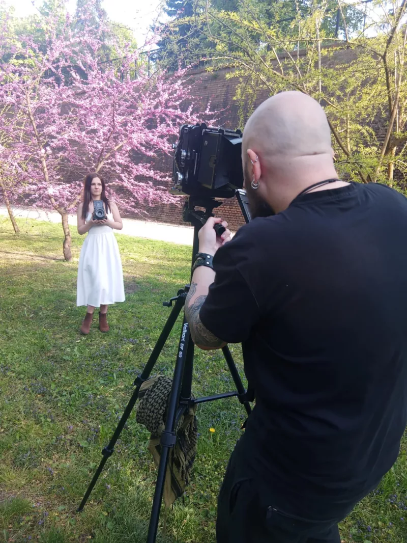 Fotograf robi zdjęcie kobiecie w parku w Głogowie