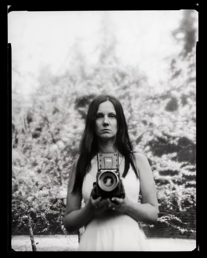 Czarno-biały portret kobiety z aparatem