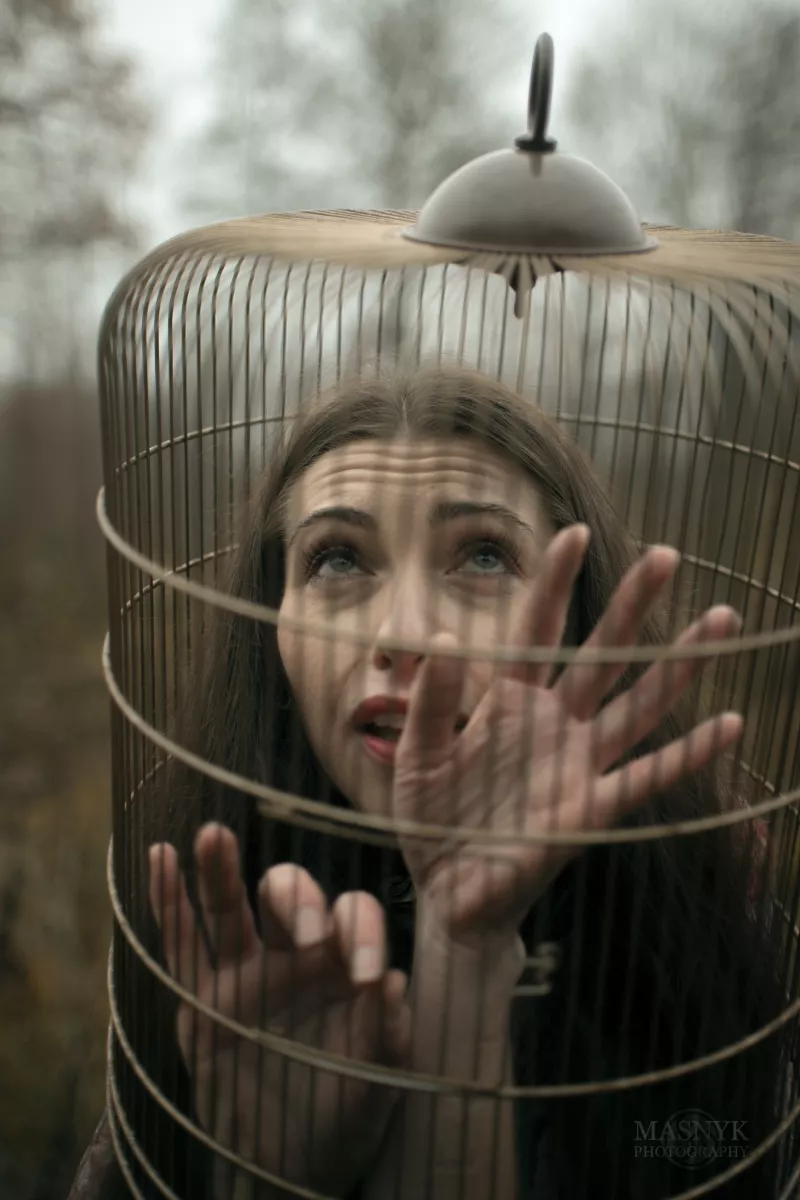 Dreamy woman with her head in a cage