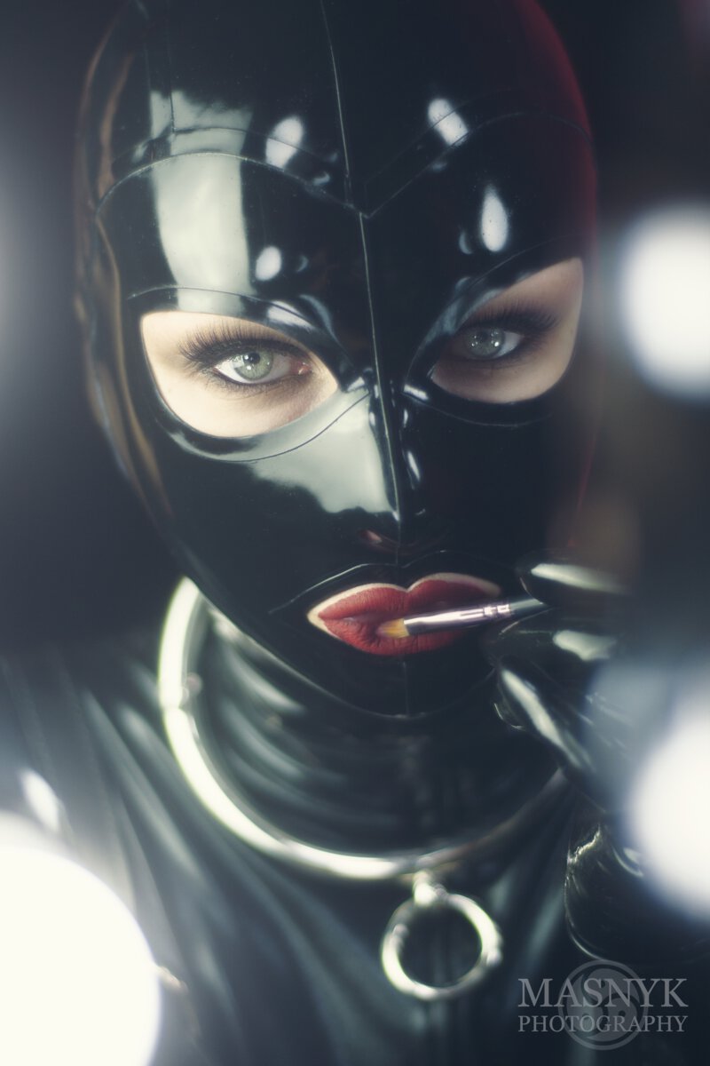 woman in latex with a collar with a seductive stare