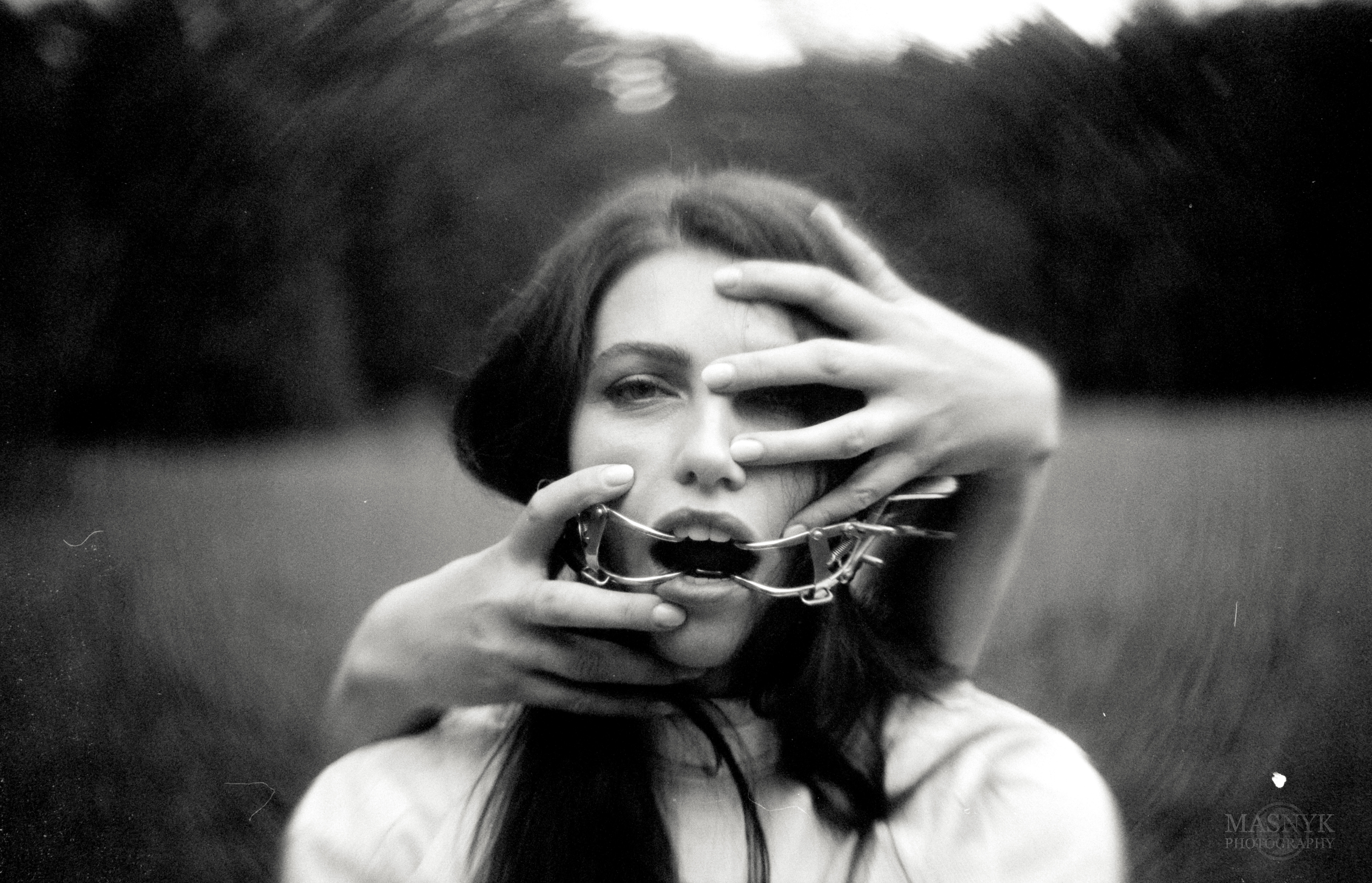 Analog horror photo. Gagged woman held by her face