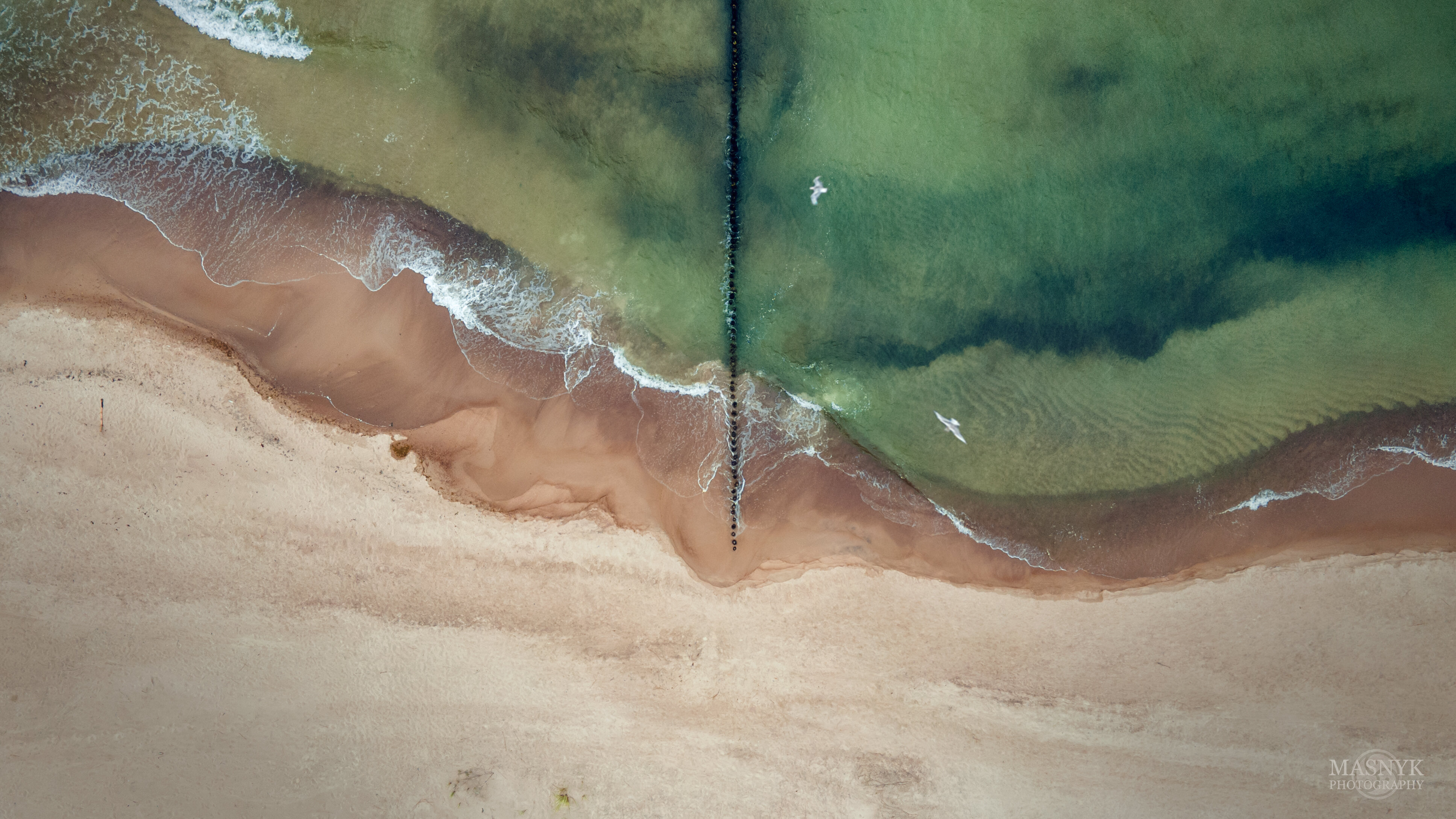 Baltic sea and breakwaters as seen from a drone