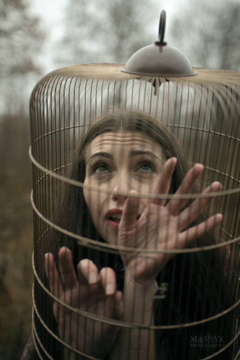 scared woman locked in a cage