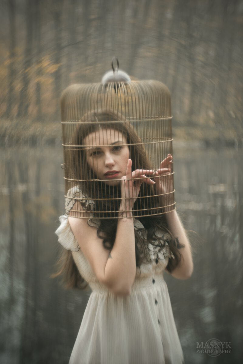beautiful woman with her head locked in a cage
