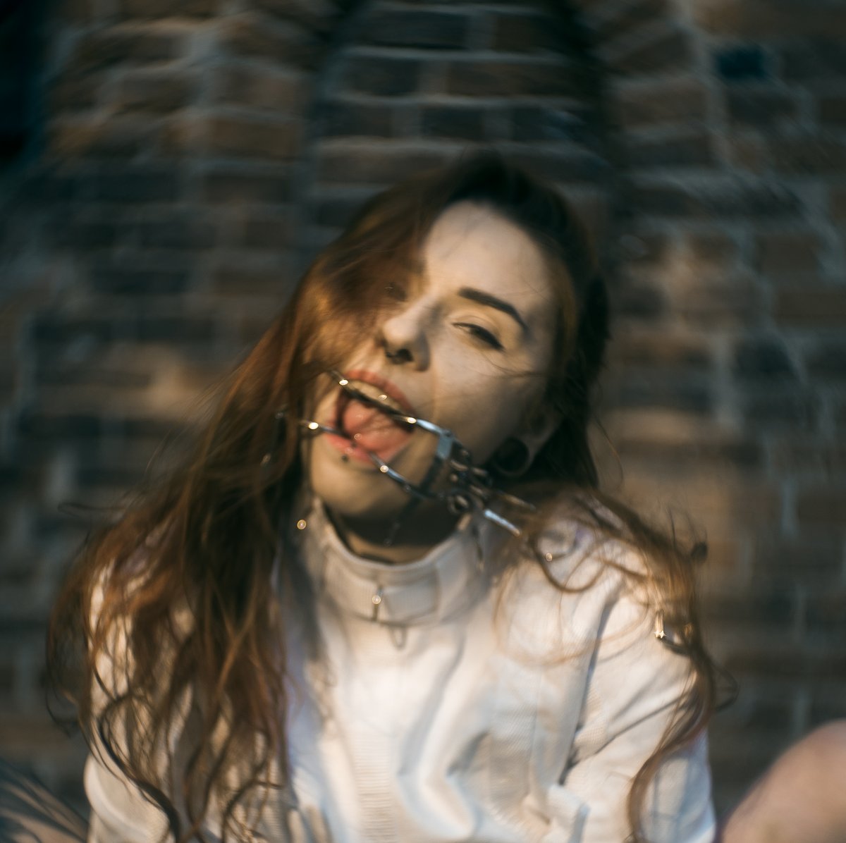 zakneblowana kobieta w kaftanie bezpieczeństwa