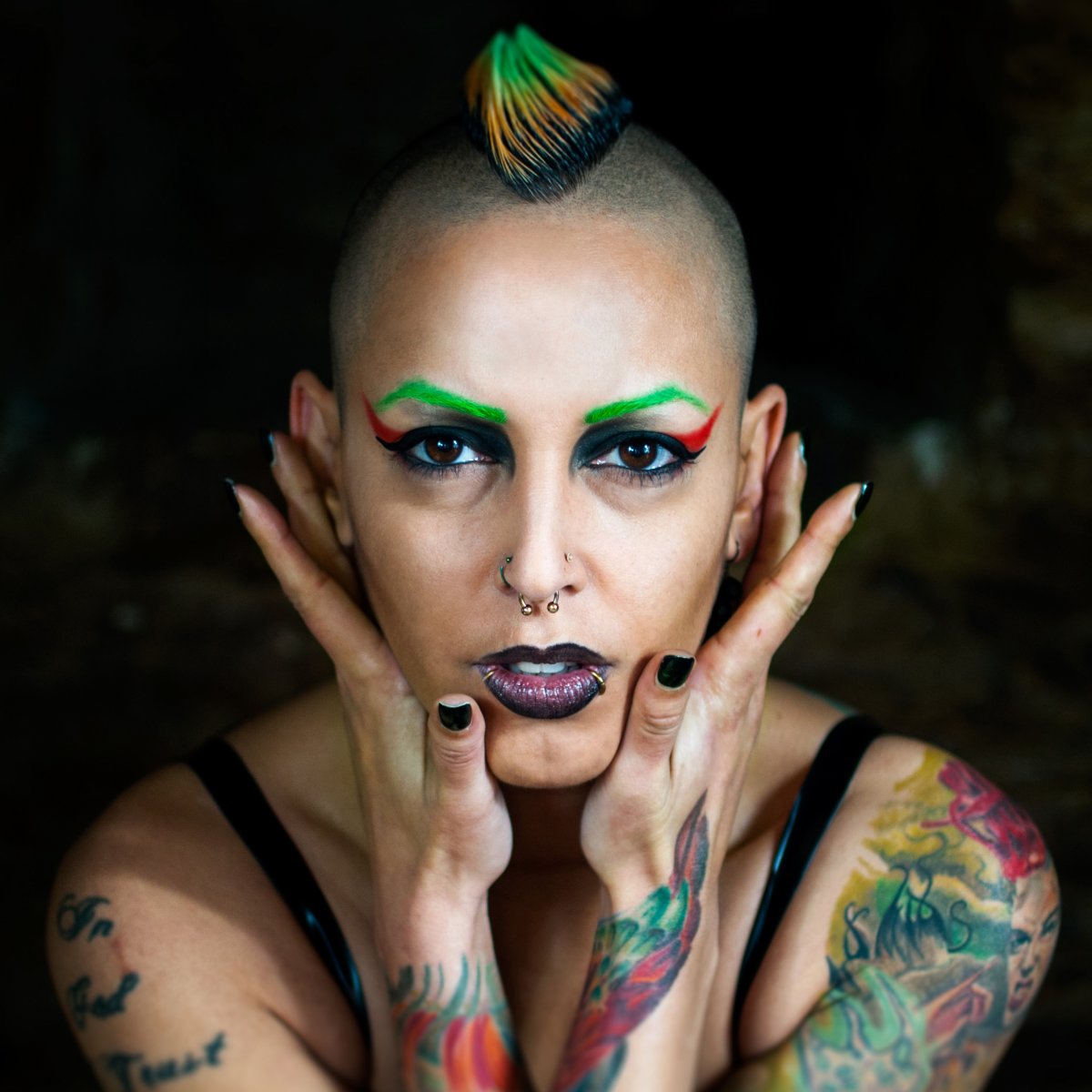 tattooed woman with piercings and colored hair